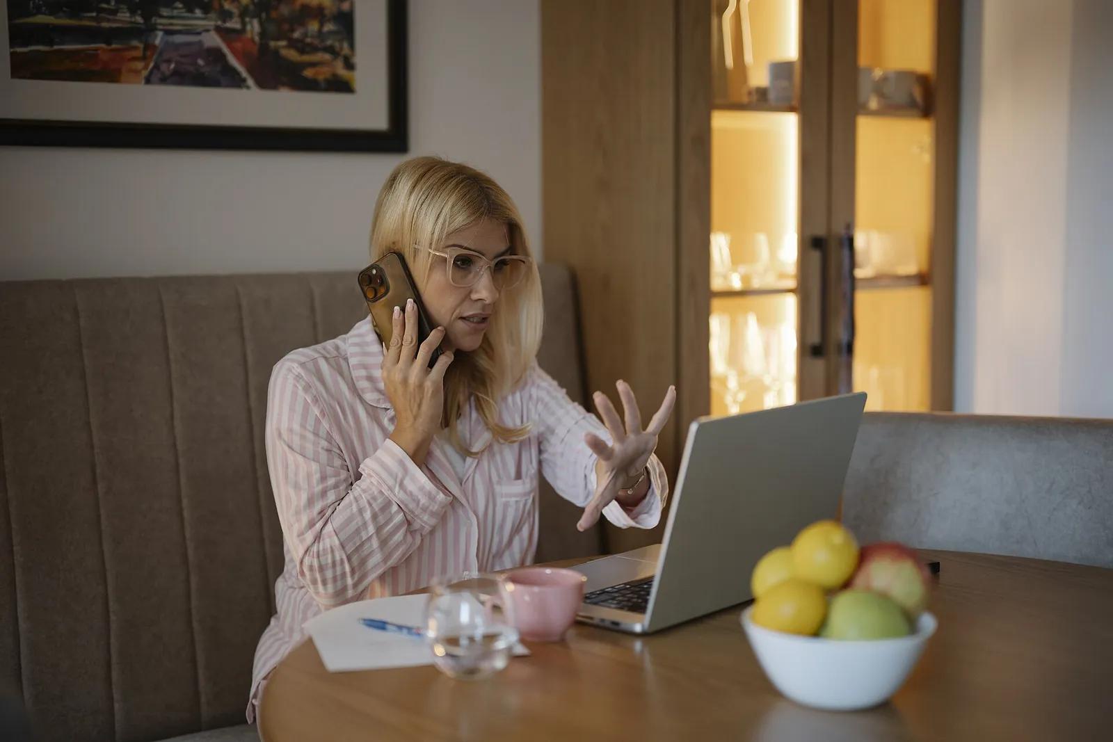 Woman on a phone call while working on a laptop