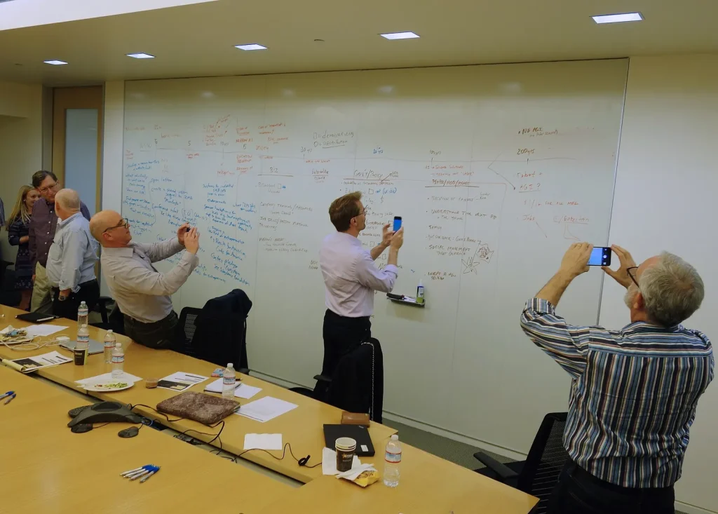 Team photographing ideas on a whiteboard after a workshop — brand strategy dubai